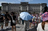 a person holds an umbrella to shield from the sun outside buckingham palace after it was announced that britain s king charles will not live there after its 10 year refurbishment finishes next year amid a heatwave in london britain photo reuters