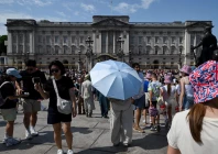 a person holds an umbrella to shield from the sun outside buckingham palace after it was announced that britain s king charles will not live there after its 10 year refurbishment finishes next year amid a heatwave in london britain photo reuters