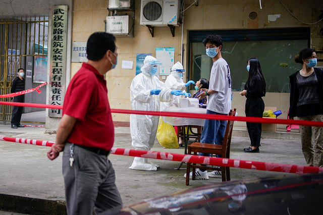 medical workers in protective suits conduct nucleic acid testings for residents at a residential compound in wuhan the chinese city hit hardest by the coronavirus disease covid 19 outbreak hubei province china may 15 2020 photo reuters