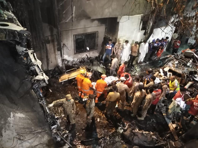 rescue workers gather at the site of a passenger plane crash in a residential area in karachi photo express