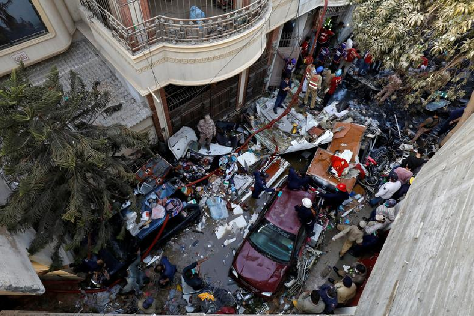 rescue workers gather at the site of a passenger plane crash in a residential area near an airport in karachi photo reuters