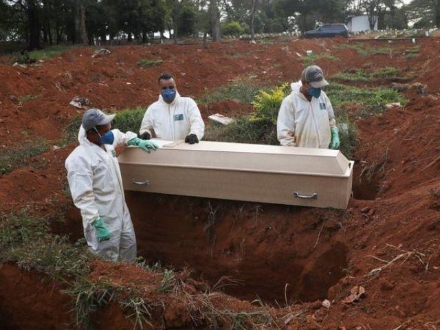 gravediggers wearing protective suits prepare to bury the coffin of a person who died from the coronavirus disease covid 19 during a ceremony with no relatives at vila formosa cemetery brazil 039 s biggest cemetery in sao paulo brazil photo reuters