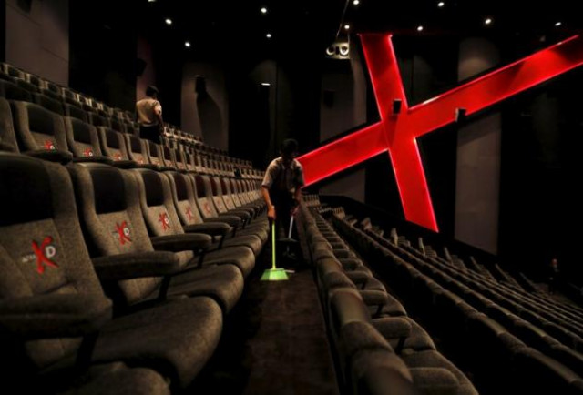 an employee at a cinemaxx theatre cleans up between screenings photo reuters an employee at a cinemaxx theatre cleans up between screenings photo reuters