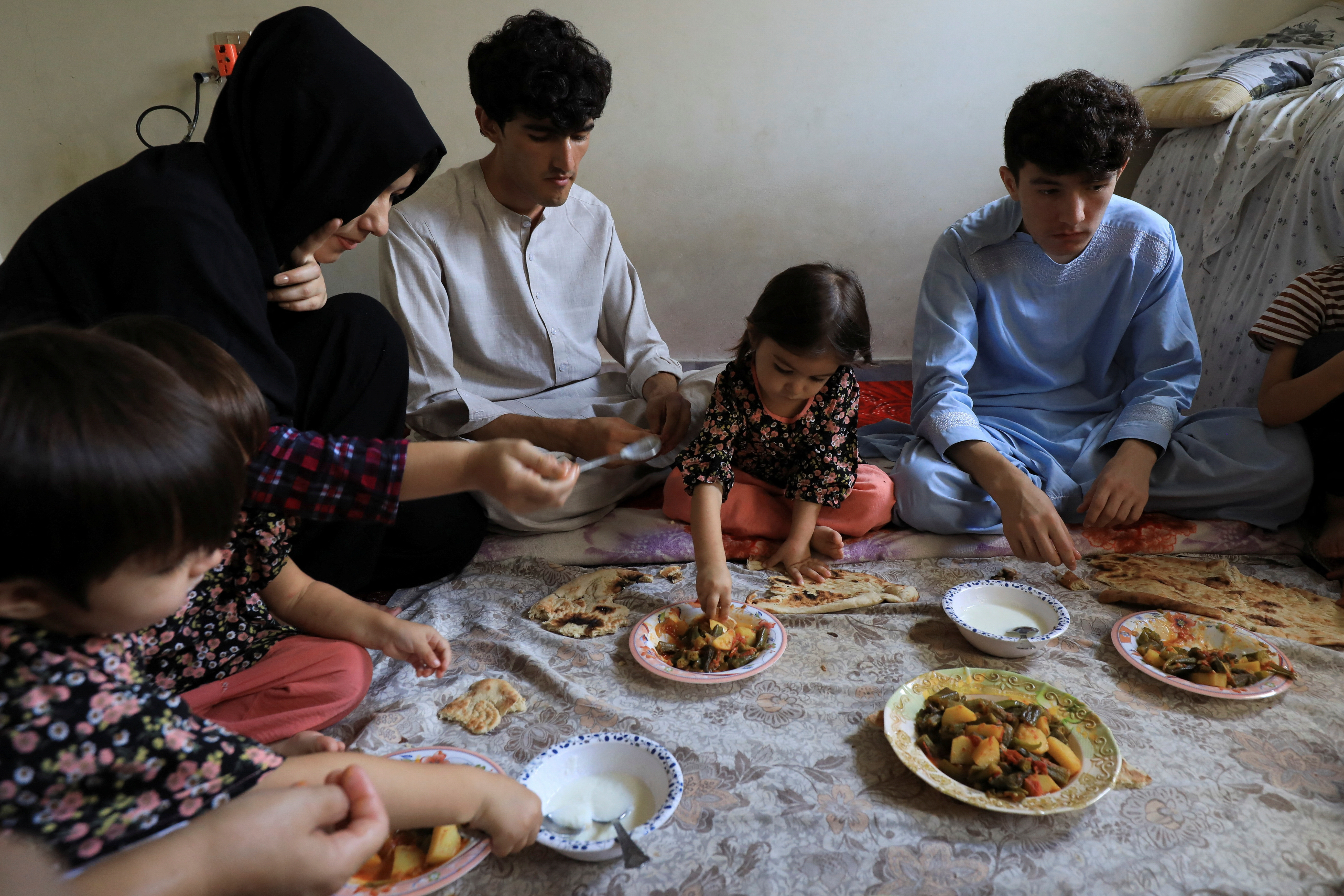marwa 18 and others have lunch at a rented house while waiting for their special visa created by western governments to protect the afghans in rawalpindi photo reuters
