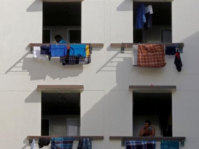 migrant workers look out of windows in a dormitory amid the coronavirus disease covid 19 outbreak in singapore may 15 2020 photo reuters file