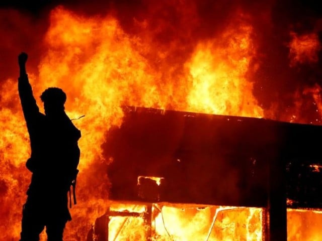 a protester gestures in front of a fire during a demonstration against the death in minneapolis police custody of african american man george floyd in minneapolis minnesota photo reuters file a protester gestures in front of a fire during a demonstration against the death in minneapolis police custody of african american man george floyd in minneapolis minnesota photo reuters file