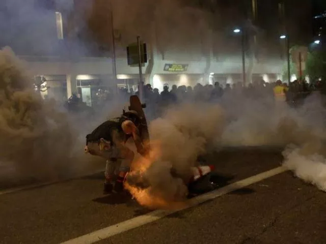 a protester shields himself from tear gas with his skateboard while demonstrating against the death in minneapolis police custody of african american man george floyd and of dion johnson who was killed in arizona outside of phoenix police headquarters in phoenix arizona us photo reuters a protester shields himself from tear gas with his skateboard while demonstrating against the death in minneapolis police custody of african american man george floyd and of dion johnson who was killed in arizona outside of phoenix police headquarters in phoenix arizona us photo reuters