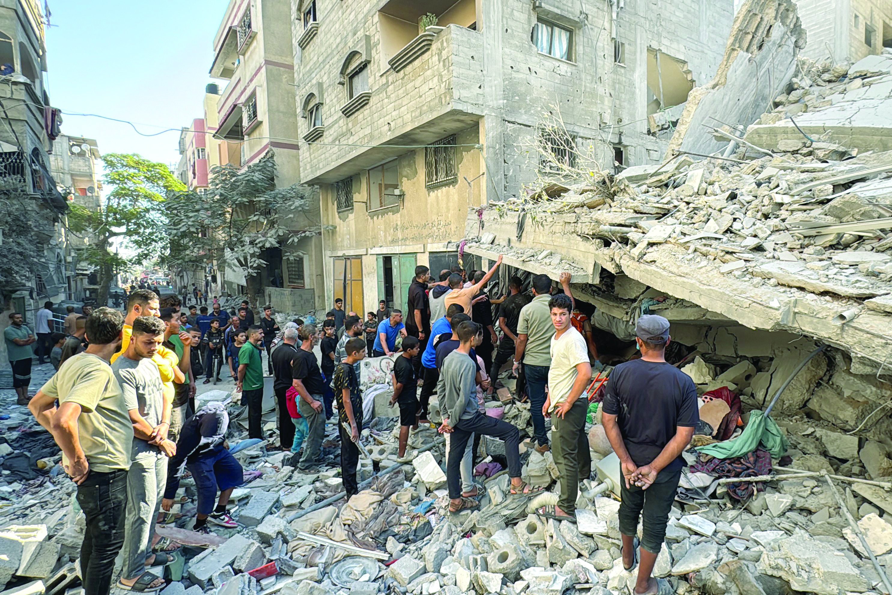 palestinians inspect the damage after an israeli air strike on a residential area in beit lahia the northern gaza strip photo afp