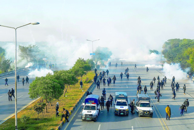policemen fire tear gas shells to disperse pti supporters in islamabad photo afp policemen fire tear gas shells to disperse pti supporters in islamabad photo afp