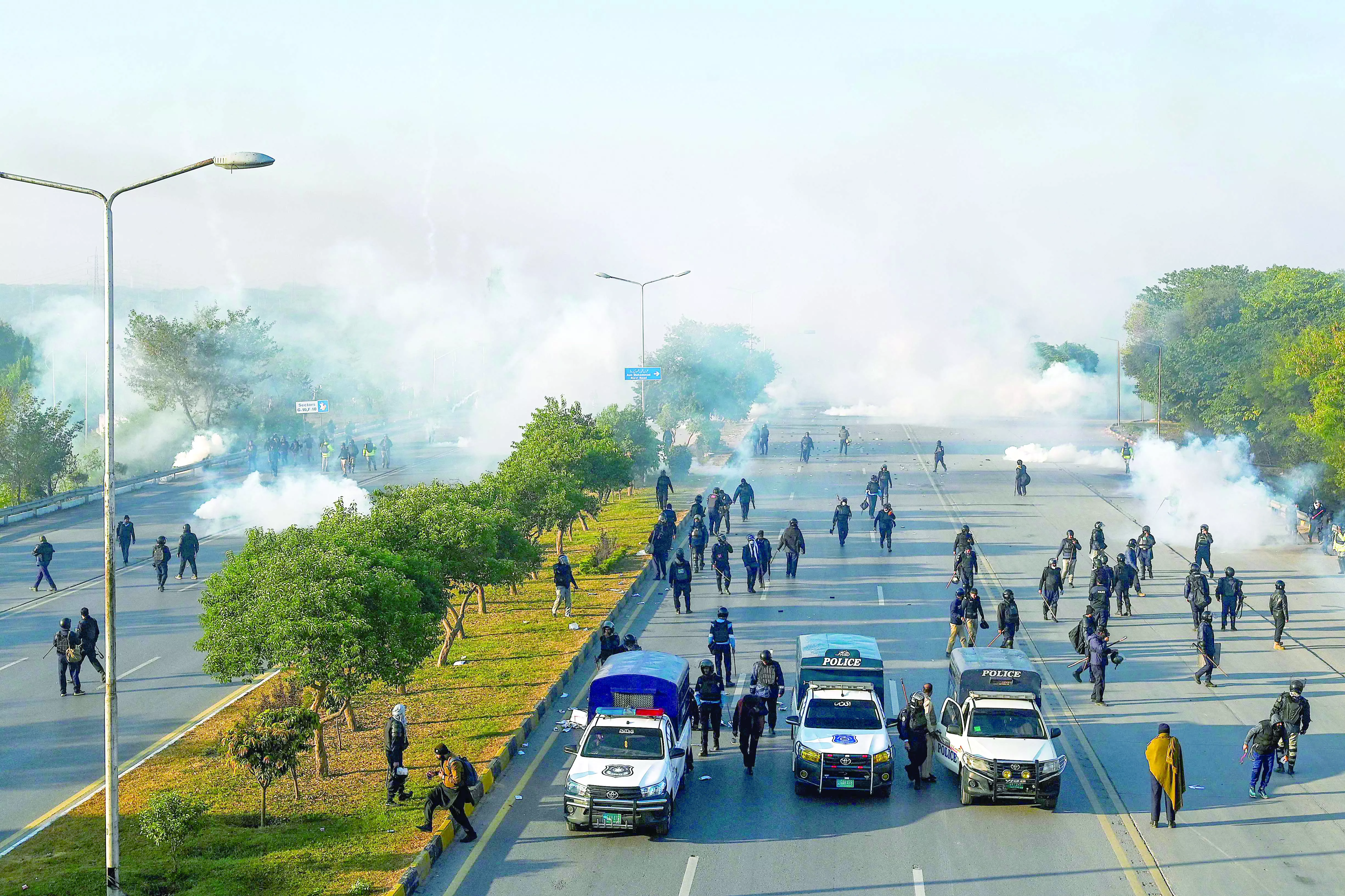 policemen fire tear gas shells to disperse pti supporters in islamabad photo afp policemen fire tear gas shells to disperse pti supporters in islamabad photo afp
