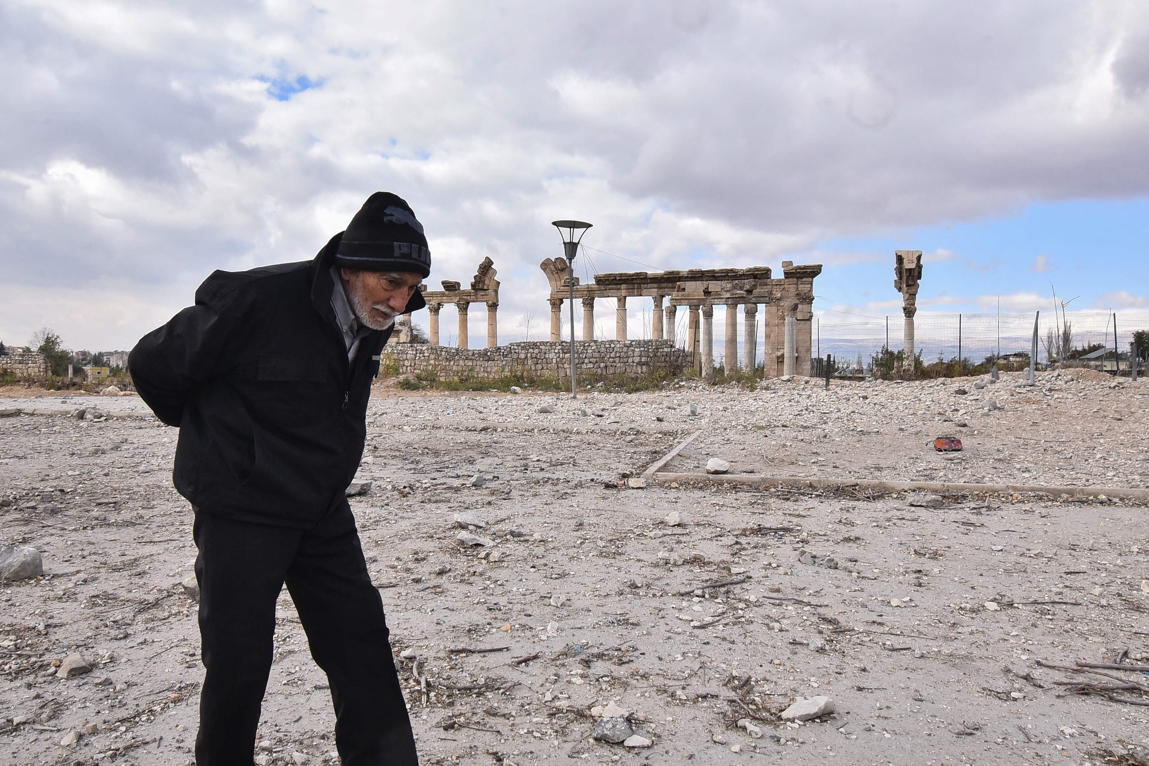 an walks through a previously bombarded area in front of the roman ruins of the ancient city of baalbek in lebanon photo afp