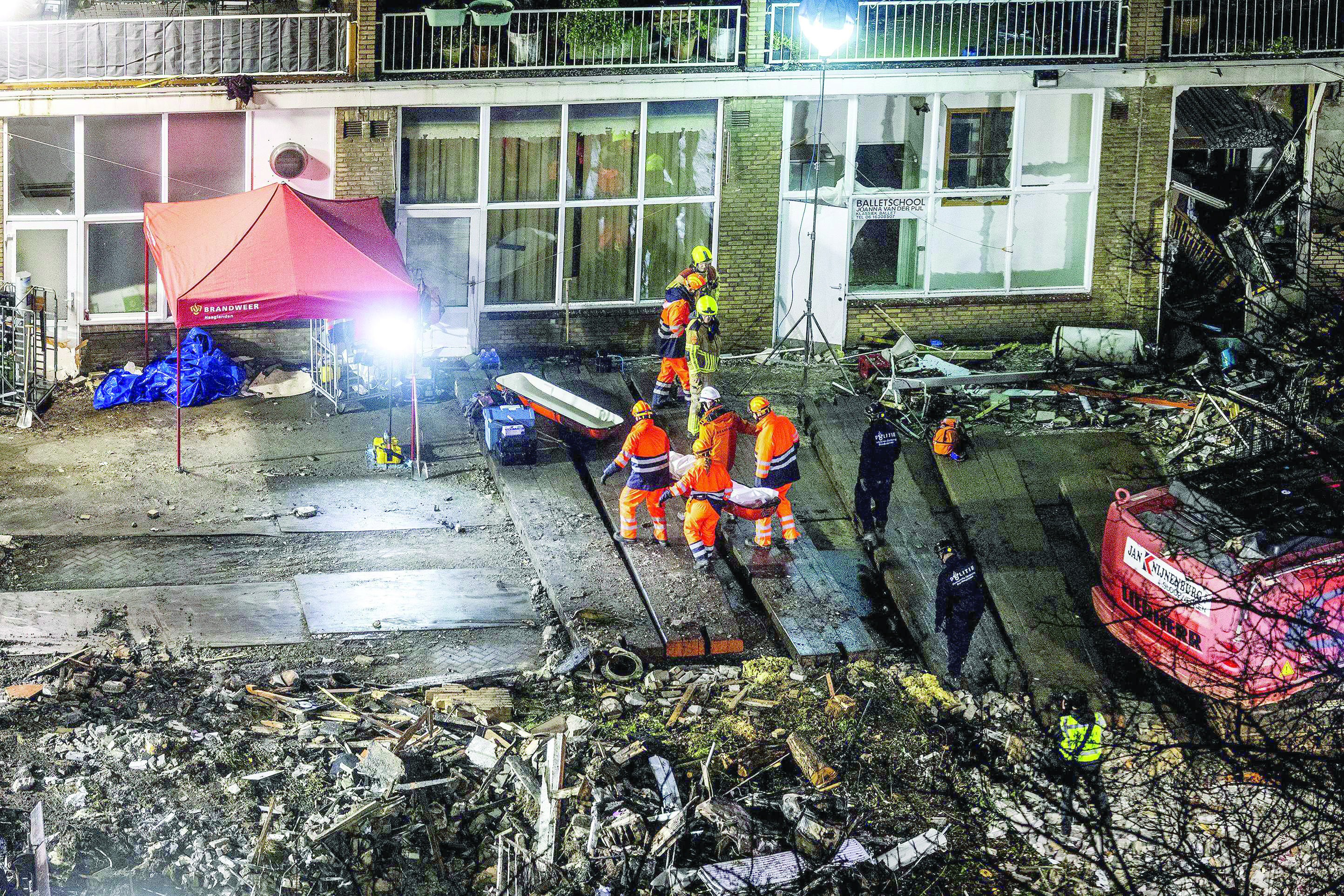 emergency services recover a body under the rubble near the tarwekamp where a three storey apartment block partially collapsed after a fire and explosion in the hague photo afp