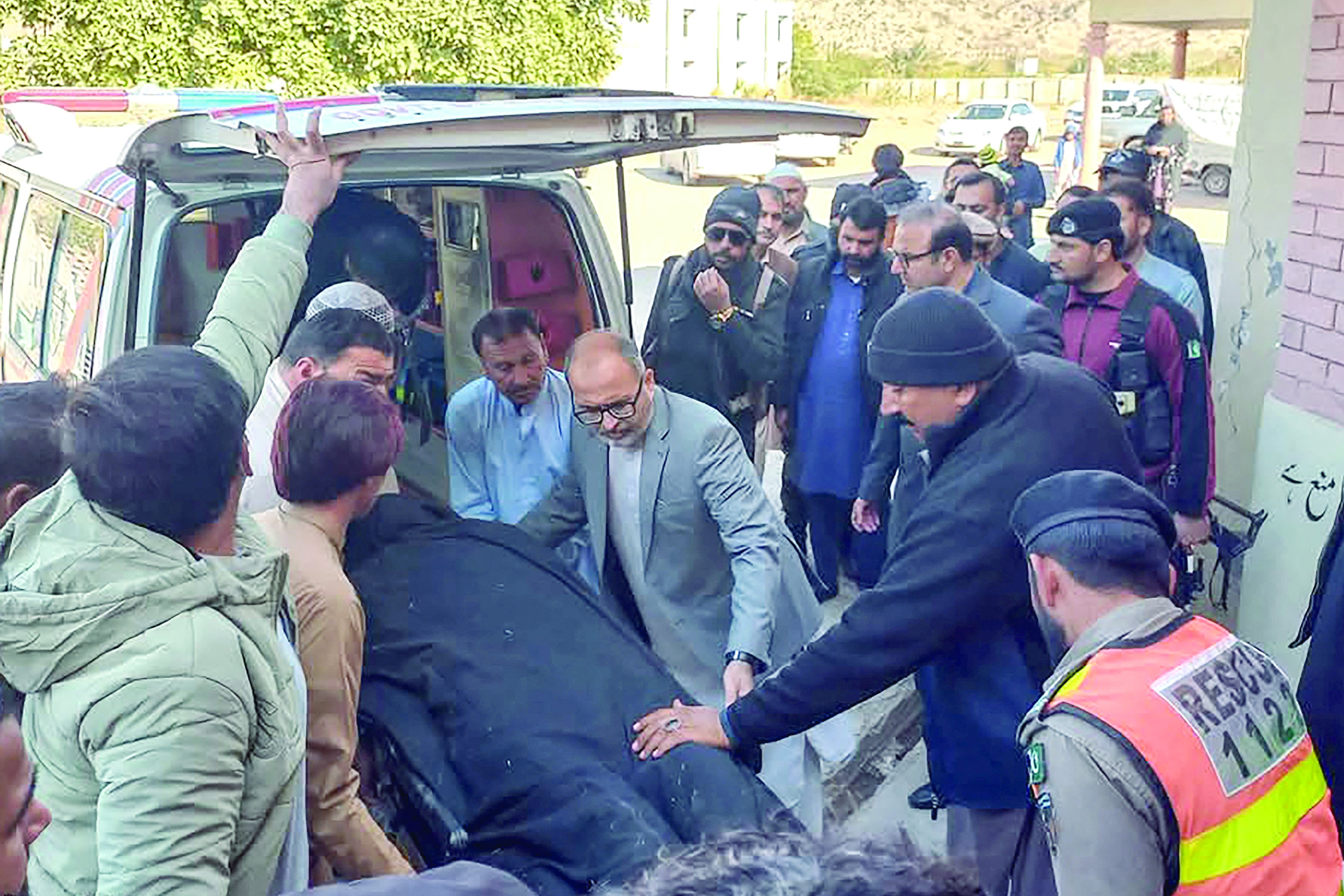 people shift the body of a policeman killed in an attack on the polio vaccinators in karak photo afp