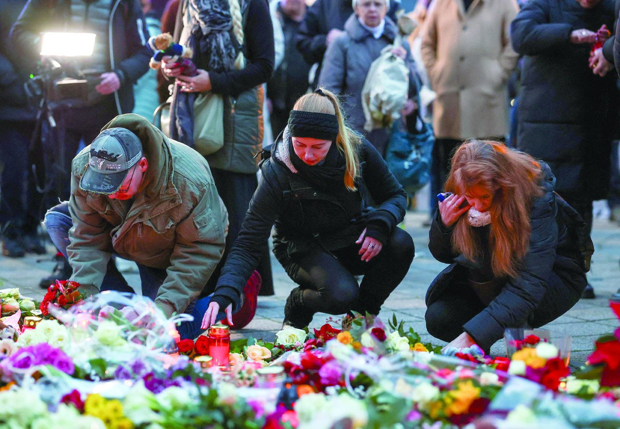 people lie candles and tributes at the site where a car drove into a crowd at a magdeburg christmas market in magdeburg germany photo reuters