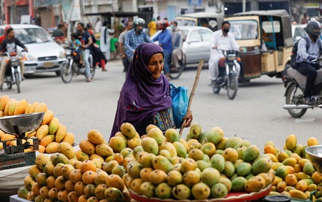 a woman walks past mango stalls at the retail market as the outbreak of the coronavirus disease covid 19 continues in karachi pakistan june 11 2020 reuters akhtar soomro