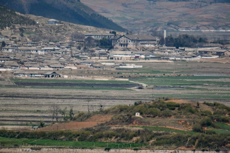 a general view of fields and buildings outside kaesong in north korea seen across the demilitarised zone from the south korean island of ganghwa photo afp