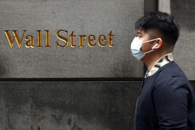 a reuters image of a man wearing a mask along the wall street a reuters image of a man wearing a mask along the wall street