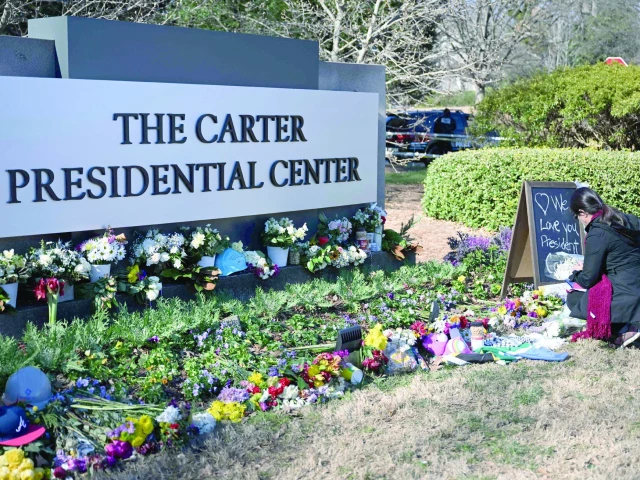 a woman lays flowers at a memorial for former us president jimmy carter in front of the carter presidential center in atlanta georgia photo afp a woman lays flowers at a memorial for former us president jimmy carter in front of the carter presidential center in atlanta georgia photo afp