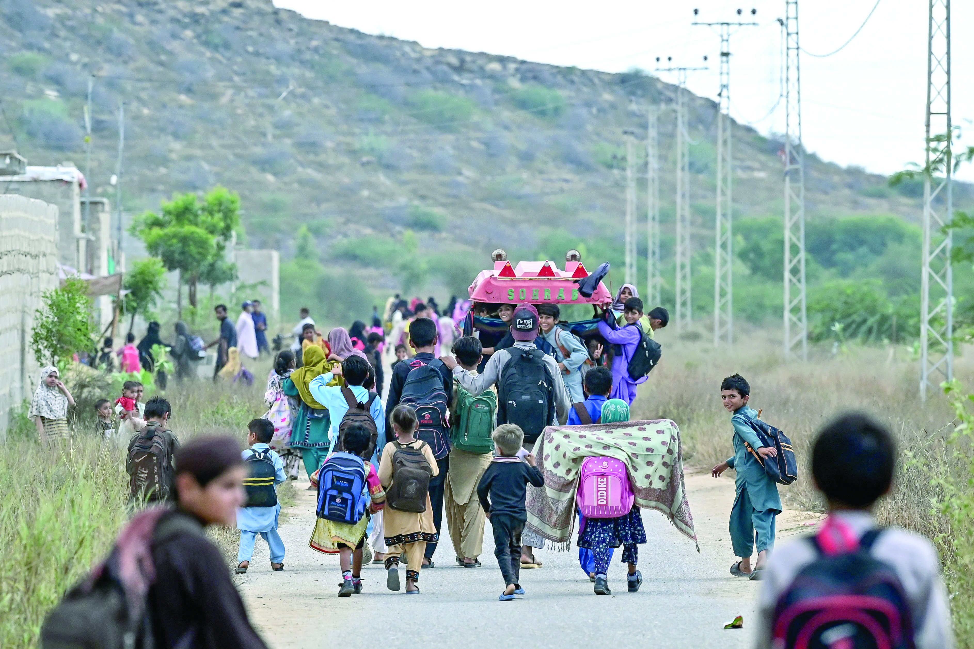 students go back to their home from a community school in abdullah goth village on the outskirts of karachi photo afp