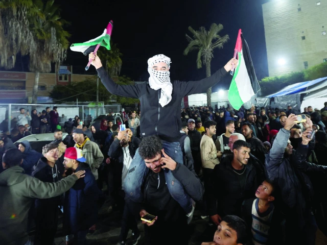 a man waves palestinian flags as people react to news on a ceasefire deal with israel in deir al balah in the central gaza strip photo reuters a man waves palestinian flags as people react to news on a ceasefire deal with israel in deir al balah in the central gaza strip photo reuters
