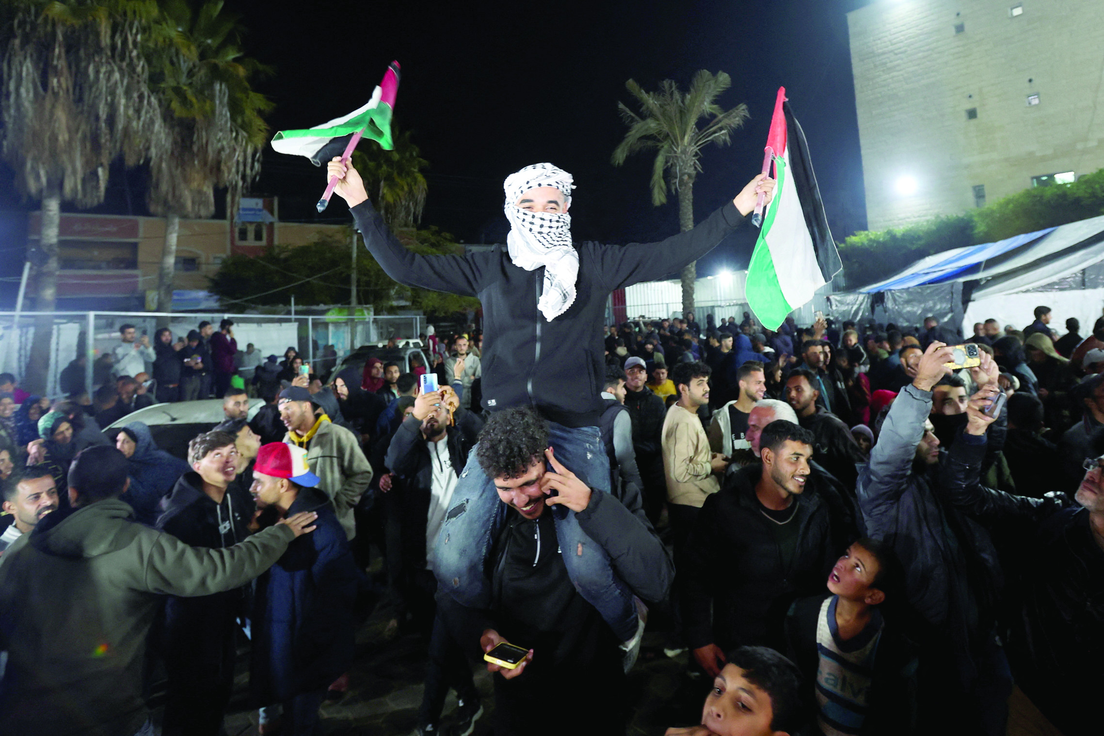 a man waves palestinian flags as people react to news on a ceasefire deal with israel in deir al balah in the central gaza strip photo reuters