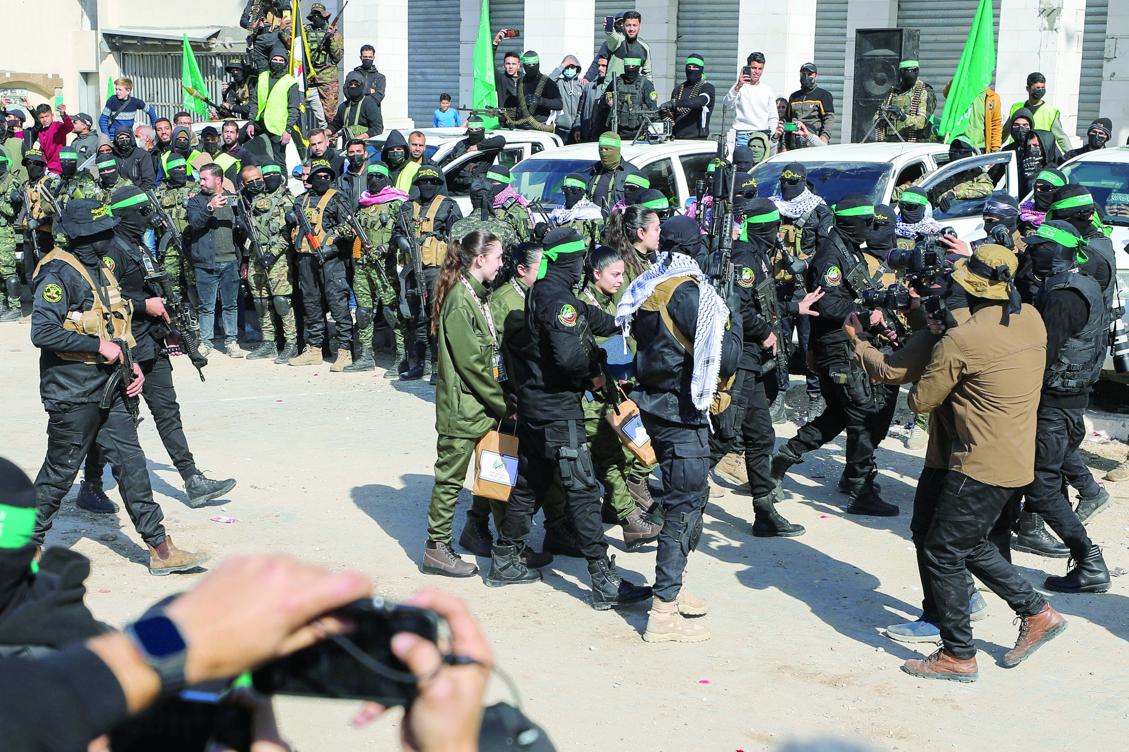 hamas fighters escort four israeli hostages to hand them over to a red cross team in gaza city photo reuters