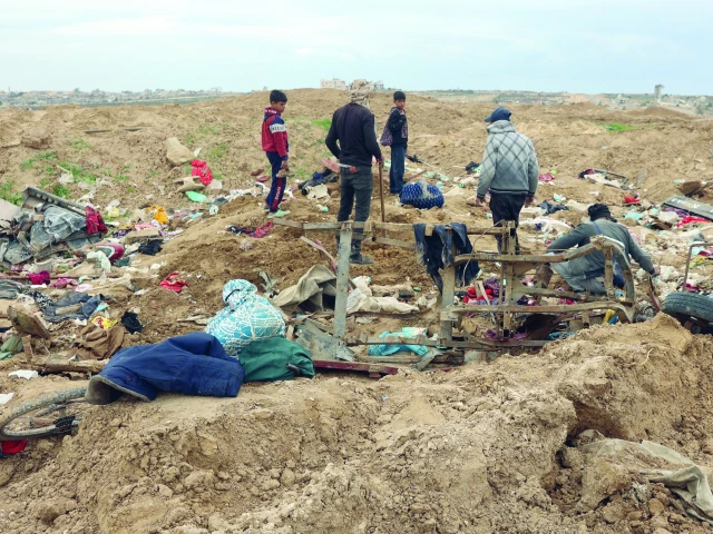 displaced palestinians inspect piles of clothes as they cross the netzarim corridor and make their way to the northern parts of the gaza strip photo afp displaced palestinians inspect piles of clothes as they cross the netzarim corridor and make their way to the northern parts of the gaza strip photo afp