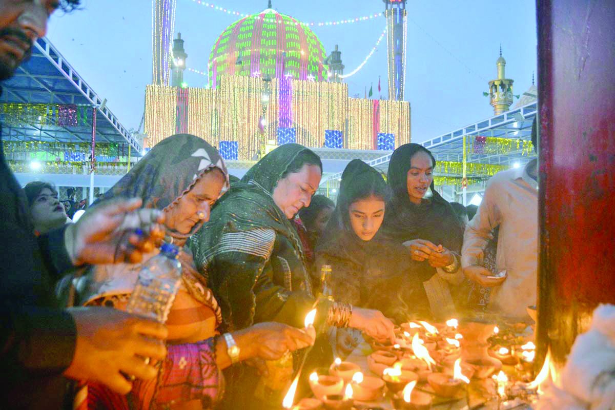 women devotees light lamps at the shrine of sufi saint lal shahbaz qalandar in hope of a wish to come true photo app