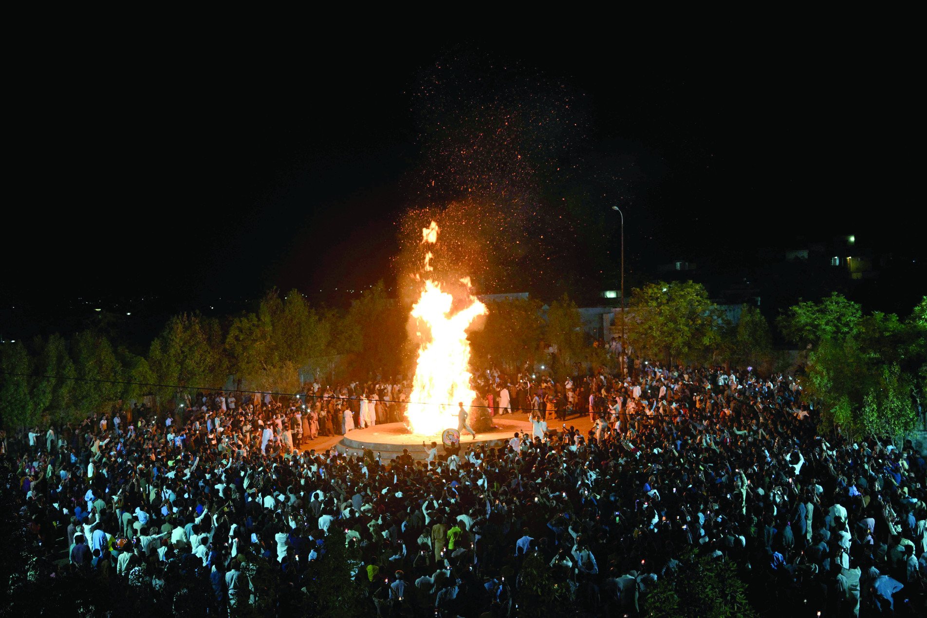 hindu community members gather around a bonfire as they celebrate the festival of colours in mithi photo afp