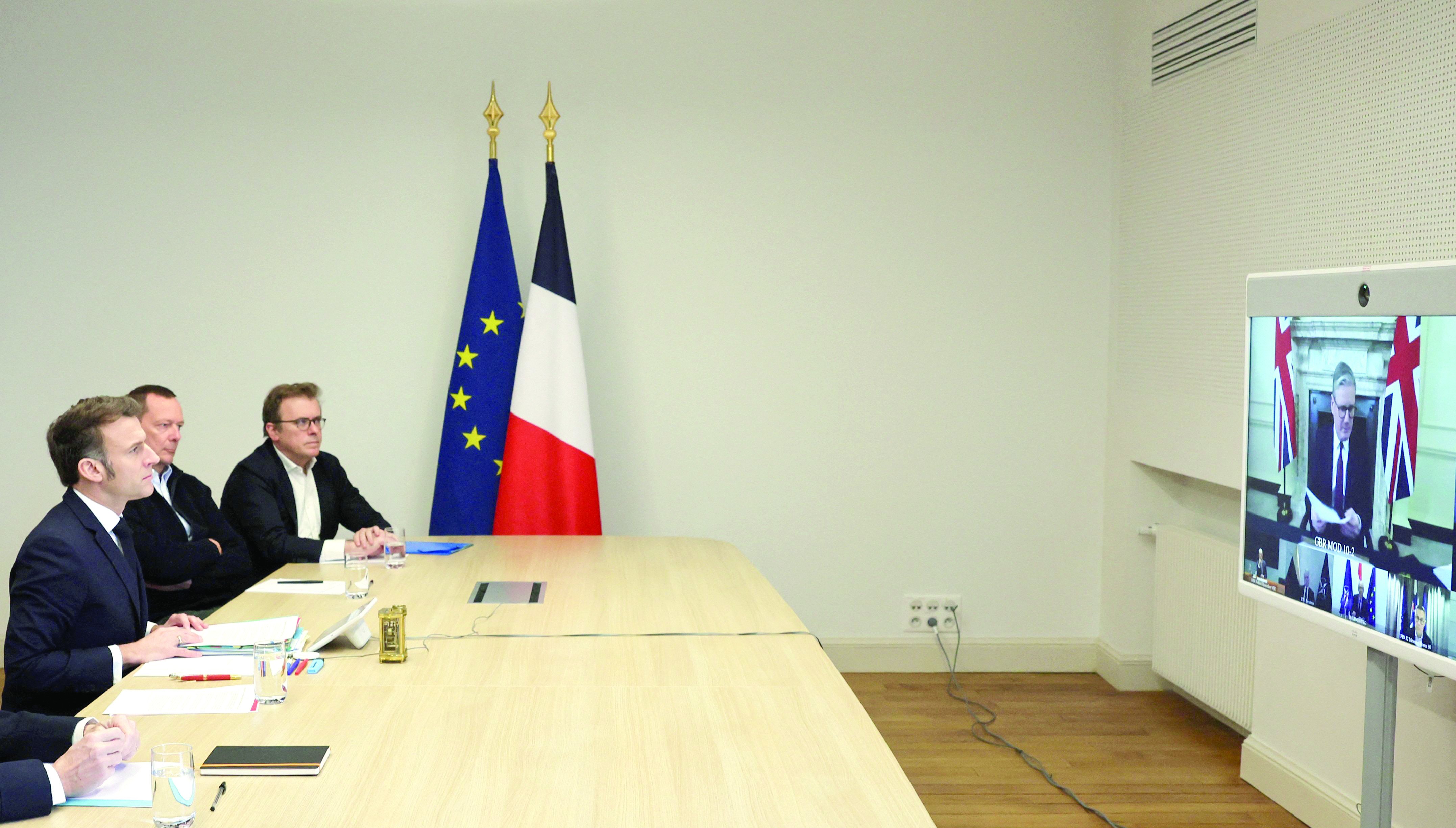 french president emmanuel macron attends a videocall as he takes part in a virtual summit held by britain s prime minister keir starmer on screen at the elysee palace in paris photo afp