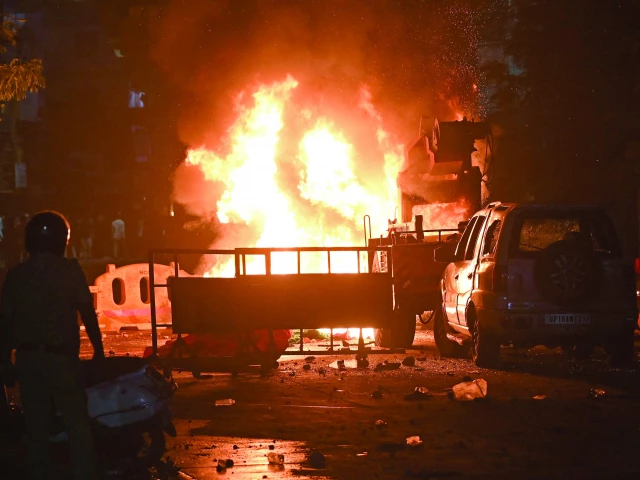 a firefighter stands near the burning vehicles in nagpur photo afp a firefighter stands near the burning vehicles in nagpur photo afp