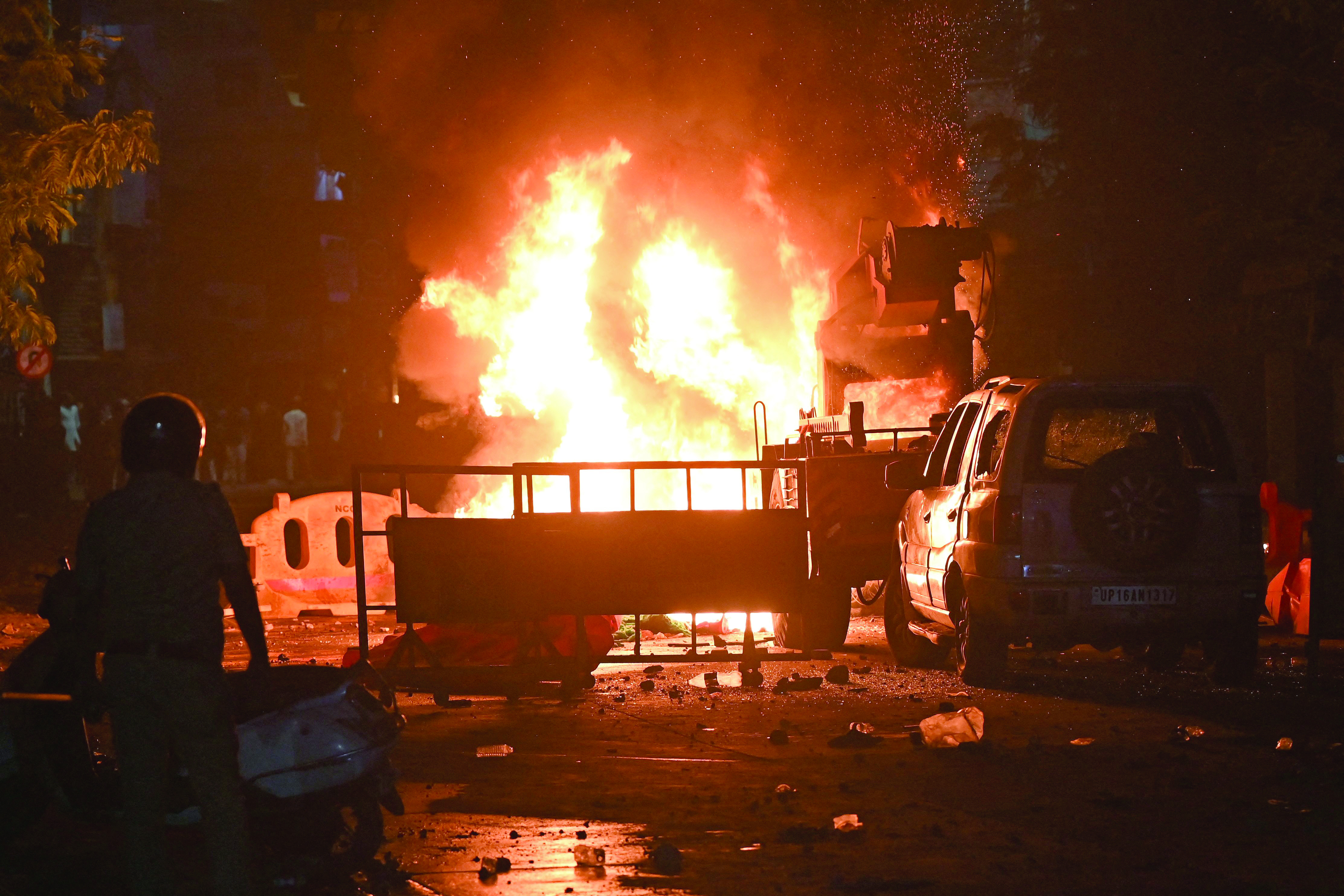a firefighter stands near the burning vehicles in nagpur photo afp a firefighter stands near the burning vehicles in nagpur photo afp