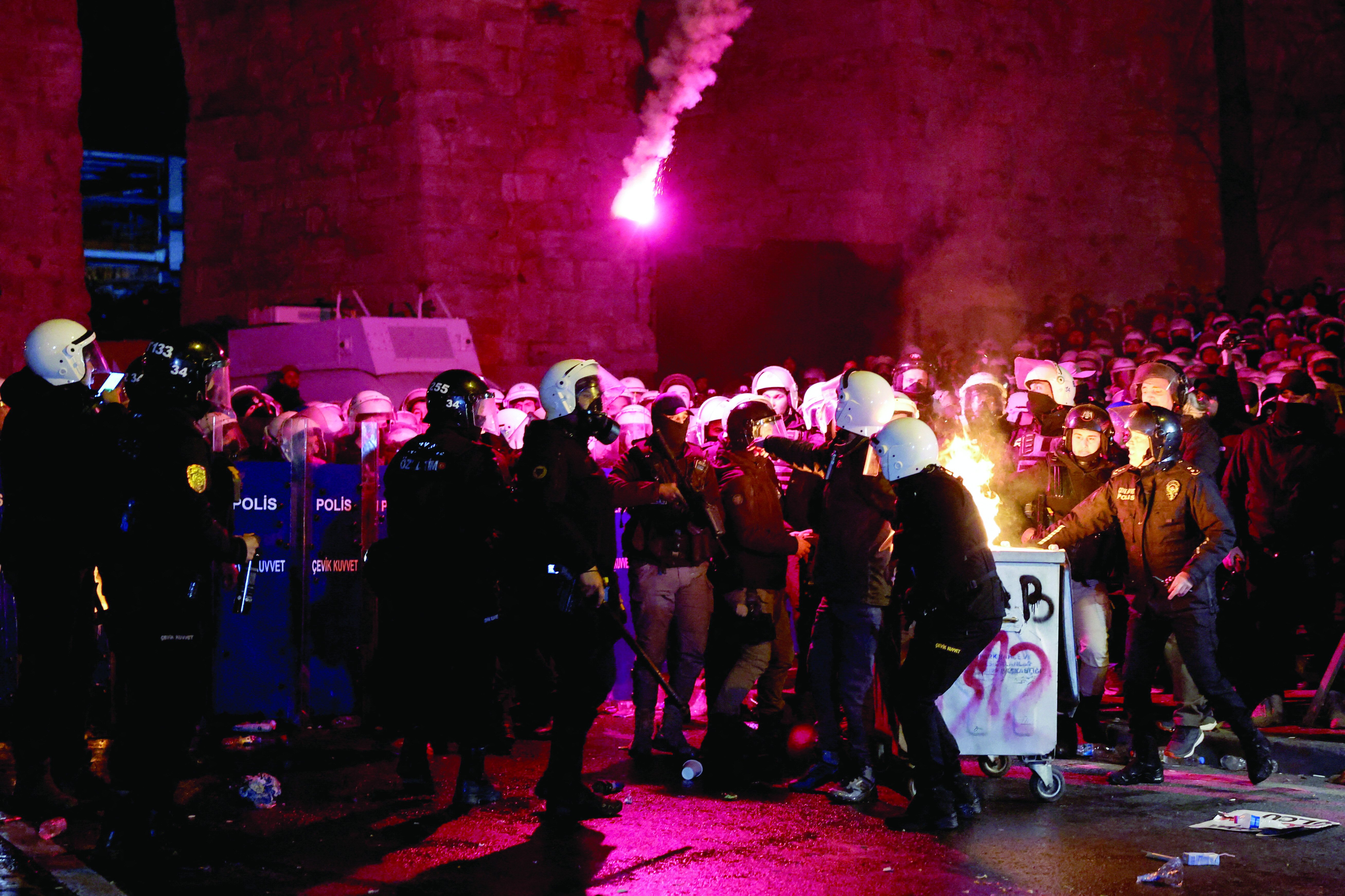 police officers intervene as flames rise from a fire in a dustbin during a protest by students against the detention of istanbul mayor ekrem imamoglu in istanbul photo reuters