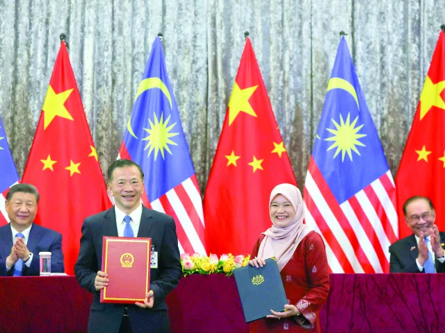 chinese and malaysian ministers pose for photographs as president xi jinping and prime minister anwar ibrahim look on in putrajaya photo afp chinese and malaysian ministers pose for photographs as president xi jinping and prime minister anwar ibrahim look on in putrajaya photo afp