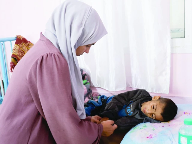 palestinian woman mona al reqep holds hand of her five year old son osama al reqep at nasser hospital where he receives treatment in khan younis photo reuters palestinian woman mona al reqep holds hand of her five year old son osama al reqep at nasser hospital where he receives treatment in khan younis photo reuters