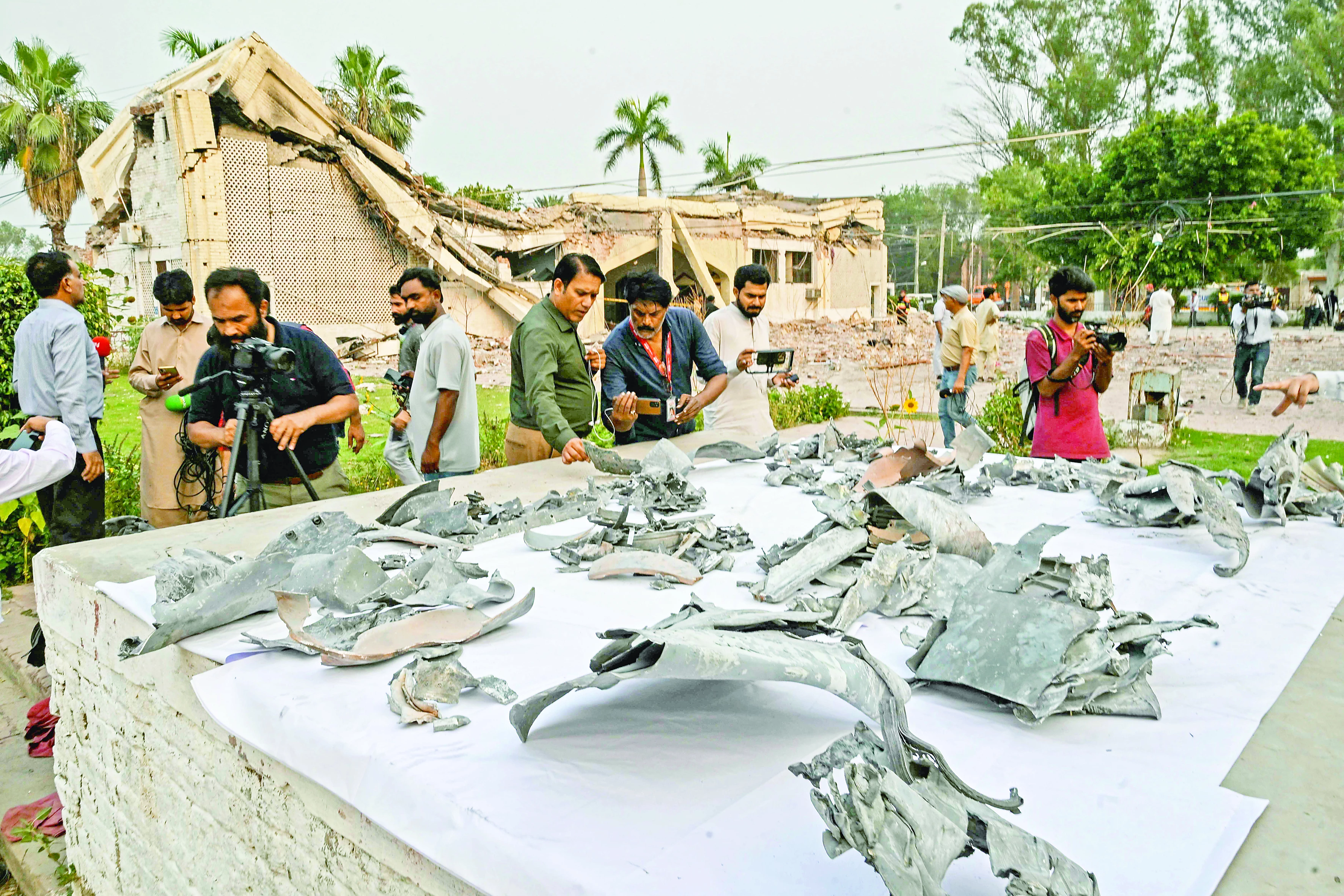 journalists look at the shards of indian missiles that hit the government health and educational complex in muridke photo afp journalists look at the shards of indian missiles that hit the government health and educational complex in muridke photo afp