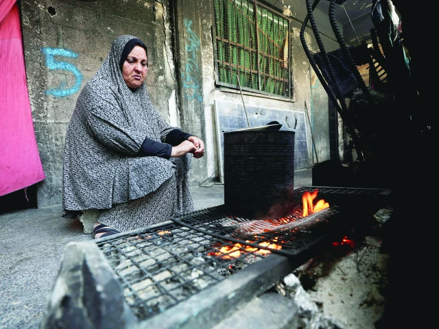 a woman cooks as she shelters in an unrwa affiliated school in jabalia refugee camp gaza photo reuters a woman cooks as she shelters in an unrwa affiliated school in jabalia refugee camp gaza photo reuters