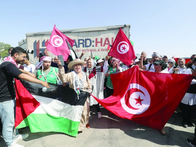 activists heading towards gaza by land wave the palestinian and tunisian flags as they arrive in zawiyah libya photo afp