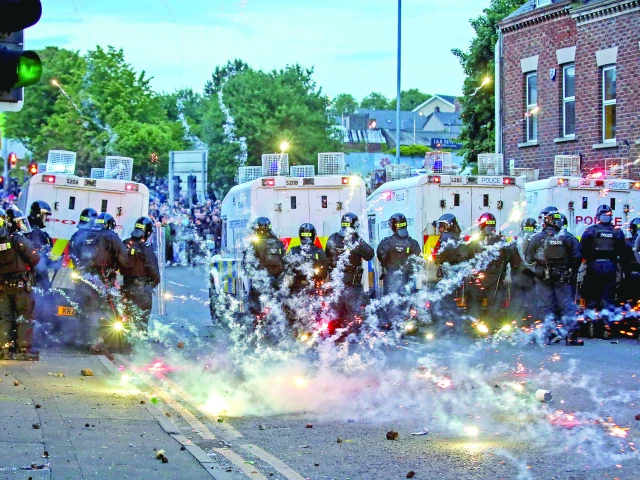 fireworks thrown at riot police illuminate the road during a third night of anti immigration demonstrations in ballymena northern ireland photo afp fireworks thrown at riot police illuminate the road during a third night of anti immigration demonstrations in ballymena northern ireland photo afp
