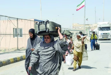 pakistanis carrying their belongings walk across the pakistan iran border after in taftan photo afp
