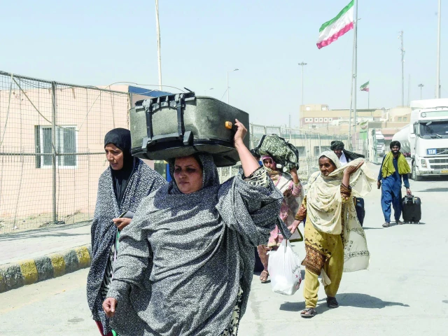 pakistanis carrying their belongings walk across the pakistan iran border after in taftan photo afp pakistanis carrying their belongings walk across the pakistan iran border after in taftan photo afp