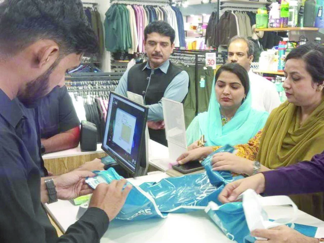 officers deliver warning notice over the use of plastic shopping bags to a shopkeeper on the autobahn road photo express