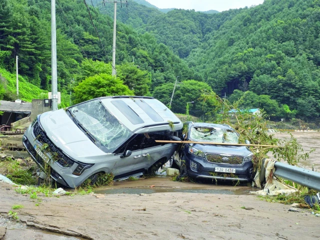 cars damaged by floodwater are seen on a road along the river due to heavy rain in gapyeong county photo afp cars damaged by floodwater are seen on a road along the river due to heavy rain in gapyeong county photo afp