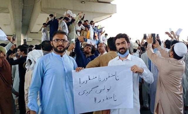two protesters hold a placard condemning the latest incident of police brutality in peshawar photo express two protesters hold a placard condemning the latest incident of police brutality in peshawar photo express