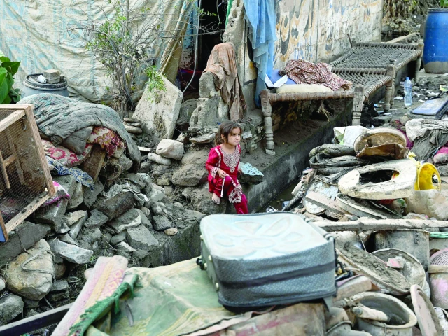 a young girl sits beside the rubble of her collapsed home in flood hit buner district photo afp