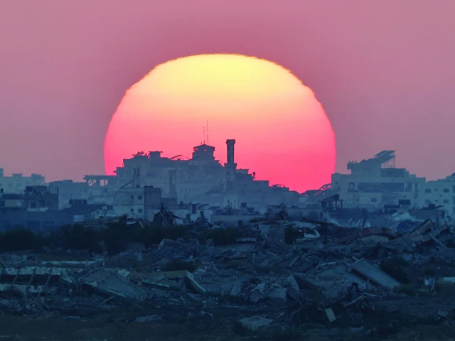 the sun sets behind destroyed buildings of gaza photo reuters