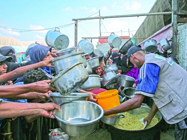 palestinian men and boys hold out their empty pots in front of a charity kitchen in khan yunis gaza strip photo af