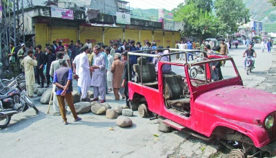 protesters place obstacles on a road during a strike in the ajk capital as government negotiators move to defuse tensions photo reuters