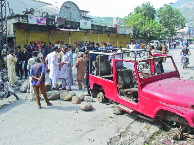 protesters place obstacles on a road during a strike in the ajk capital as government negotiators move to defuse tensions photo reuters