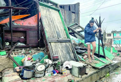 a woman salvages belongings from the rubble of her home after it collapsed during hurricane melissa s passage through santiago de cuba cuba photo afp